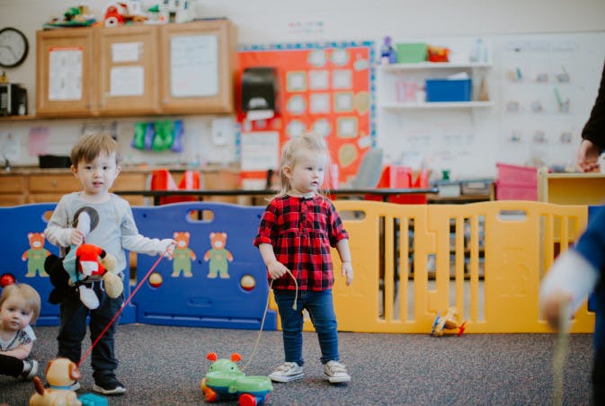 Two children playing with toys in a classroom