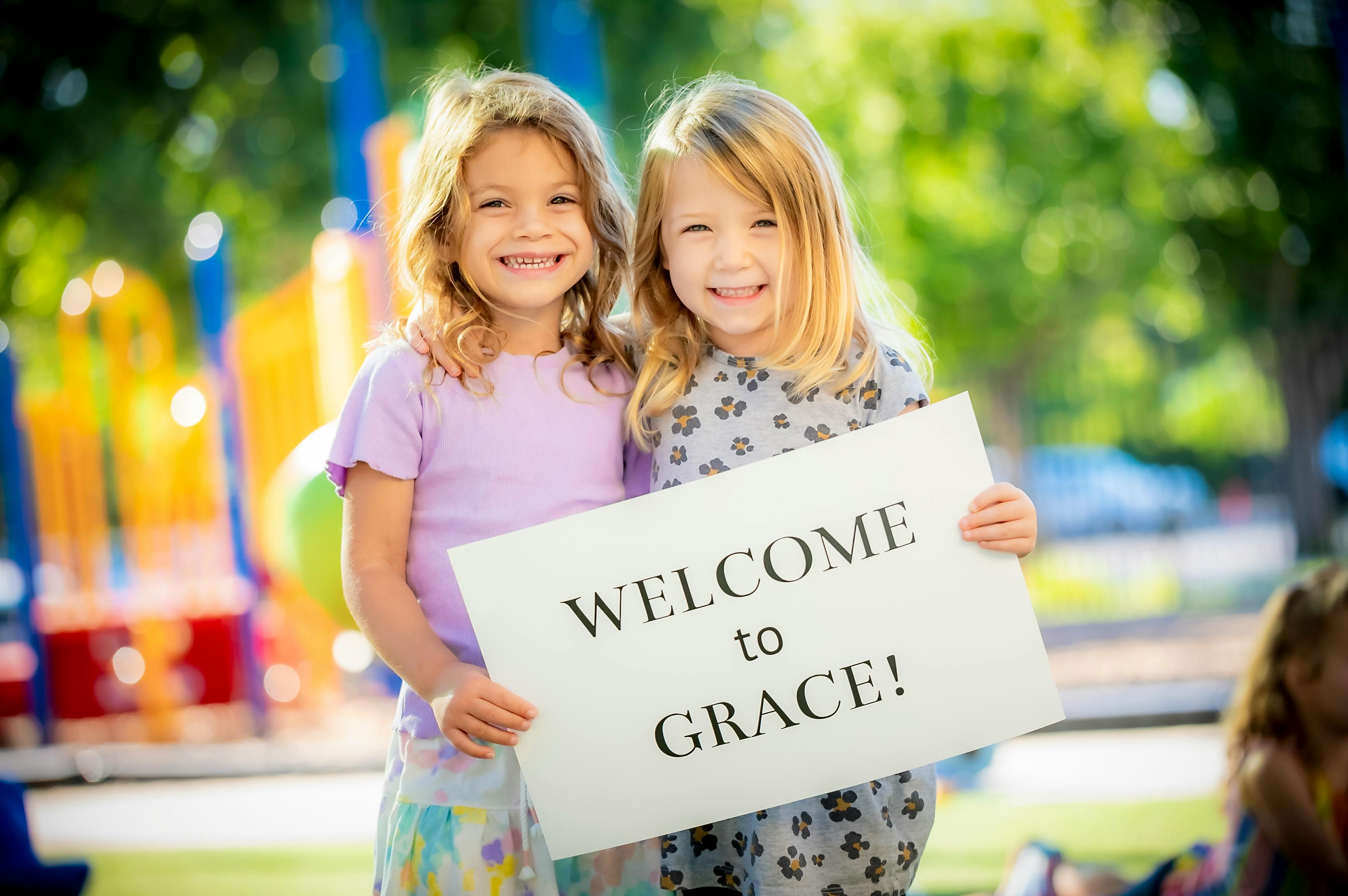 Two children holding a sign that says "WELCOME to GRACE!"