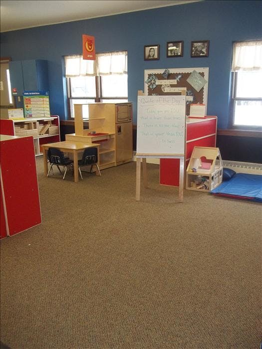 children's classroom with small tables and a whiteboard with text