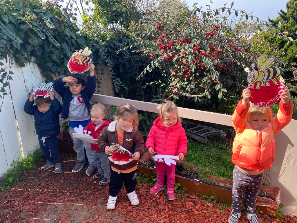 Group of children holding up crafts outdoors