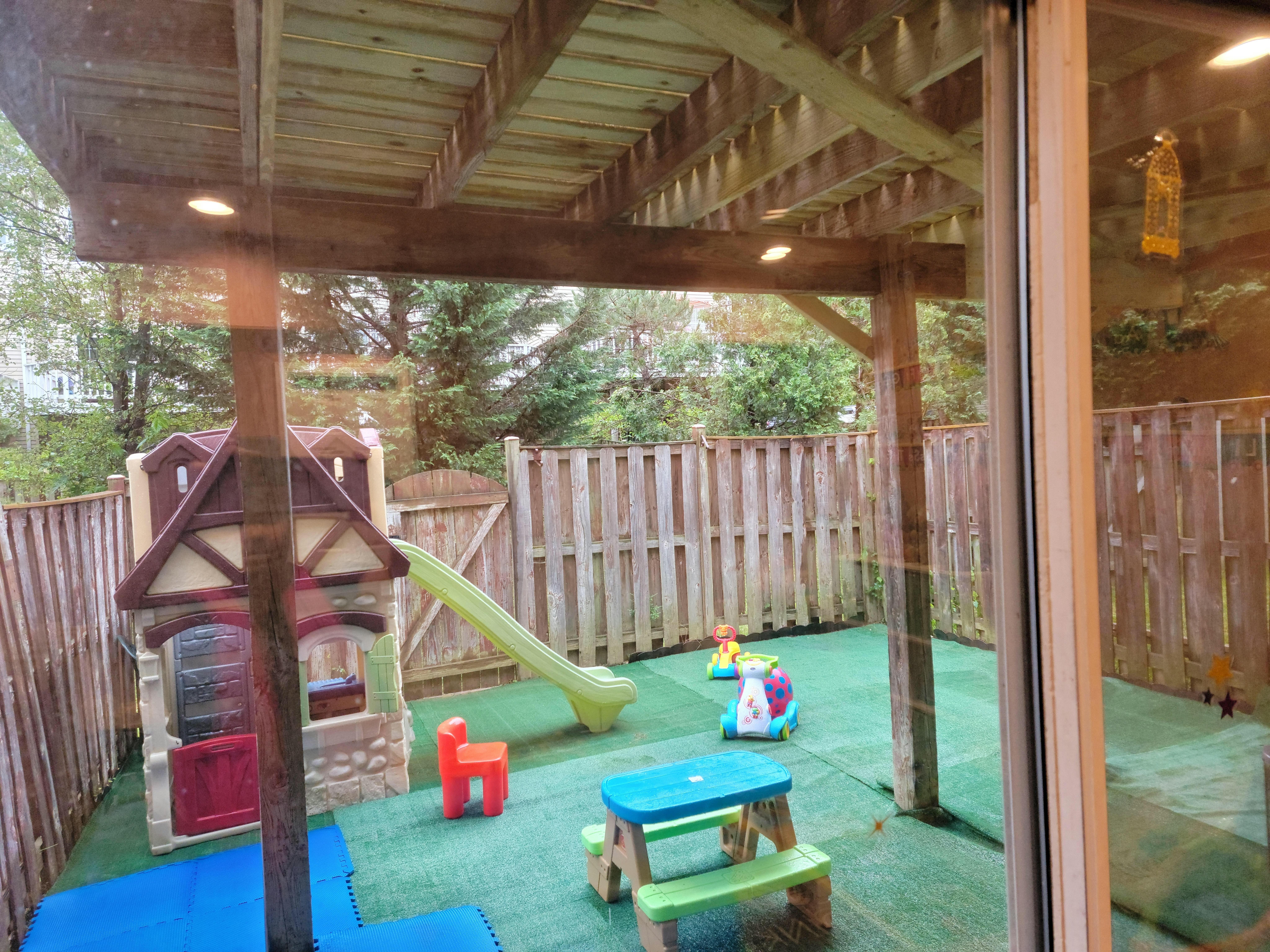 Outdoor play area with playhouse, slide, and small table