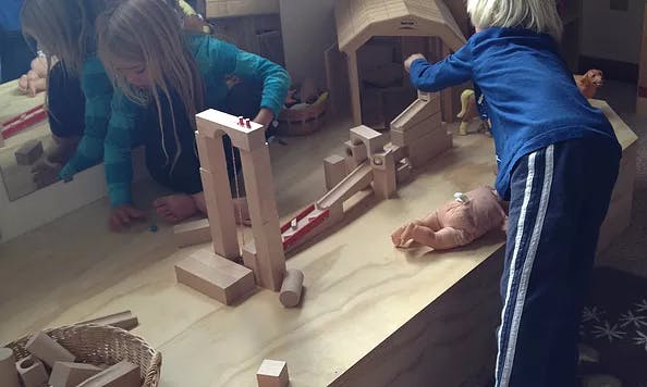 Children playing with wooden blocks and toys