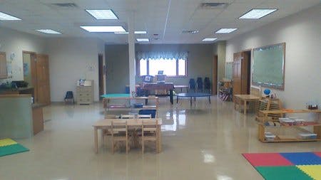 Empty classroom with small tables and chairs
