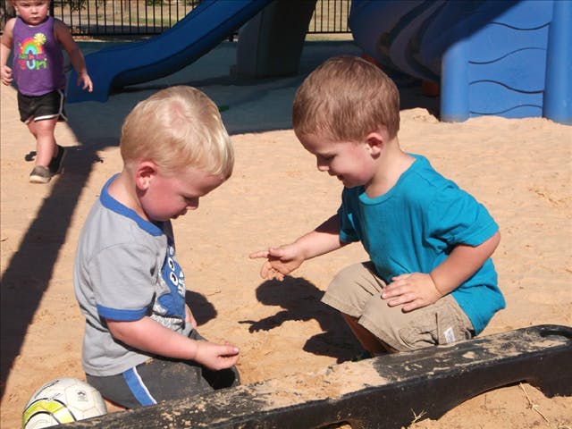 Two children playing in a sandbox