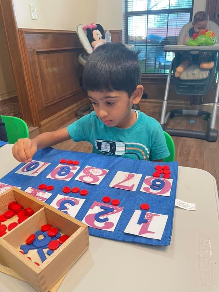 Child playing with a number learning mat and red counters