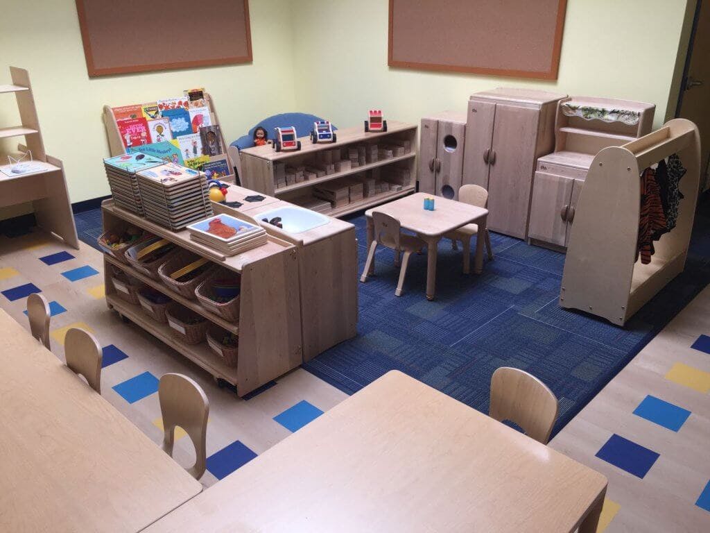 Classroom with small tables, chairs, and storage units
