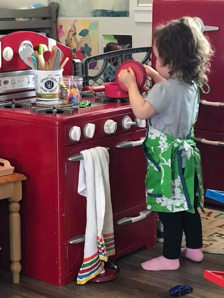 Child playing with a toy kitchen set