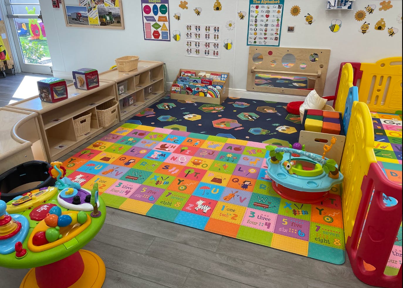 Children's play area with an alphabet mat on the floor and toys