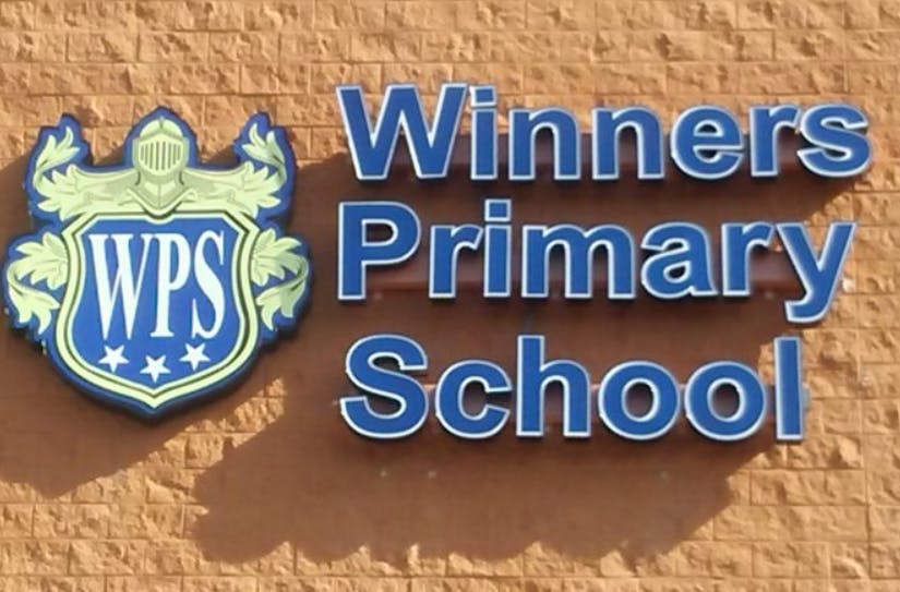Winners Primary School sign with a shield logo