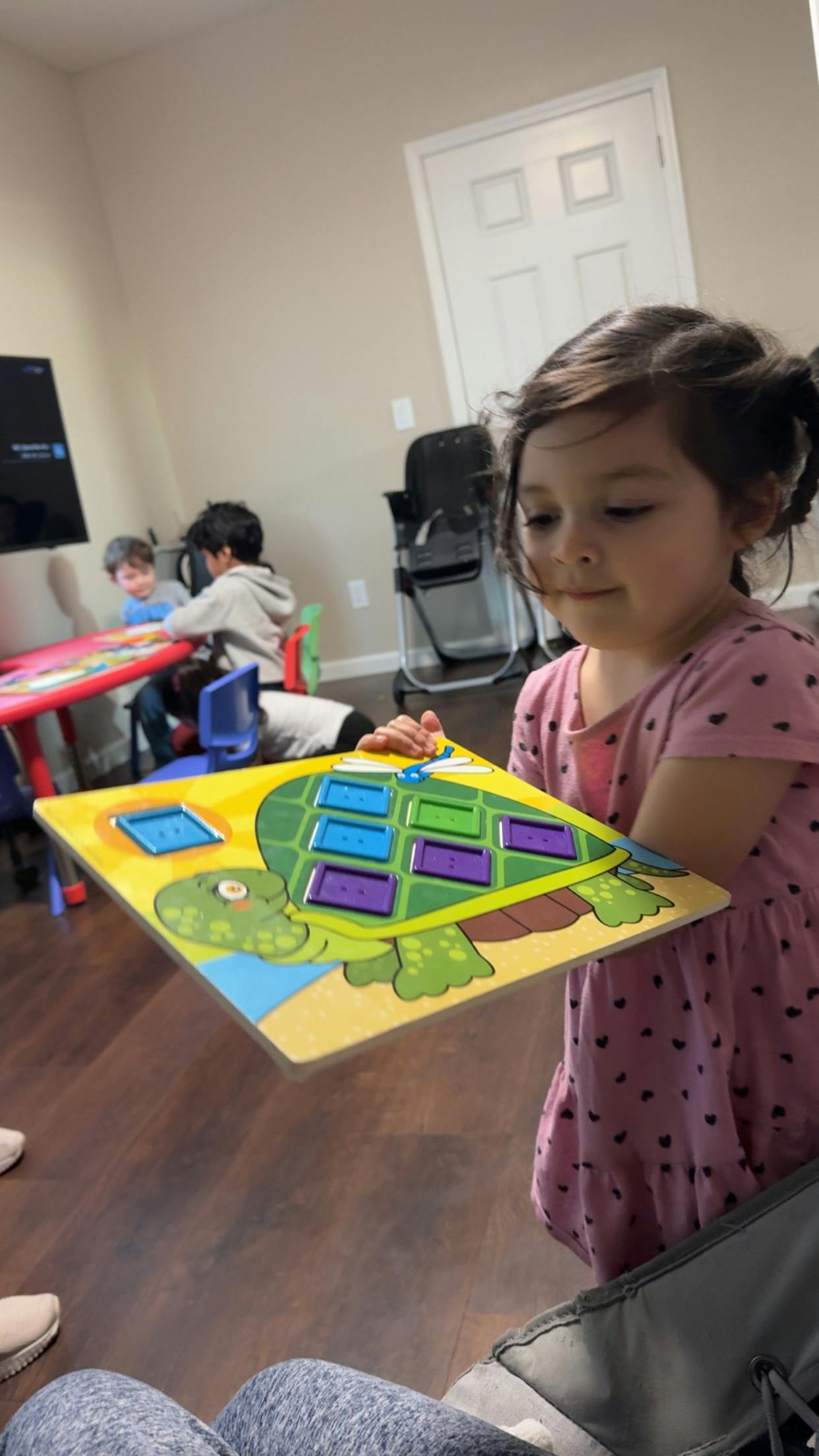Child holding a turtle-shaped puzzle board