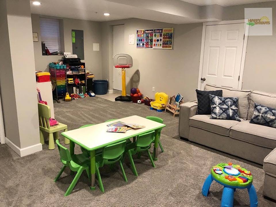 Playroom with small green table and chairs, toys, and a sofa
