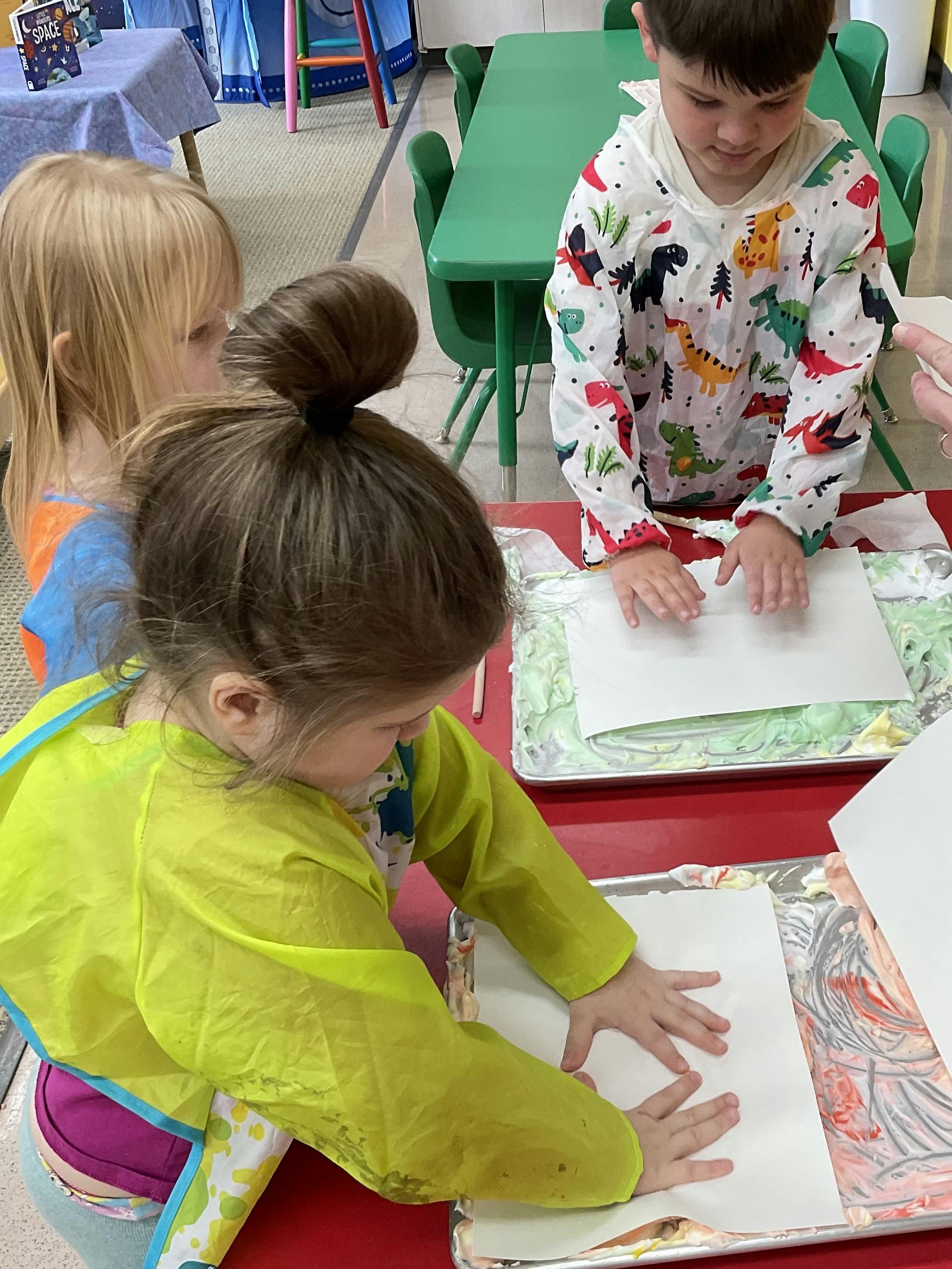 Three children doing an art project at a table
