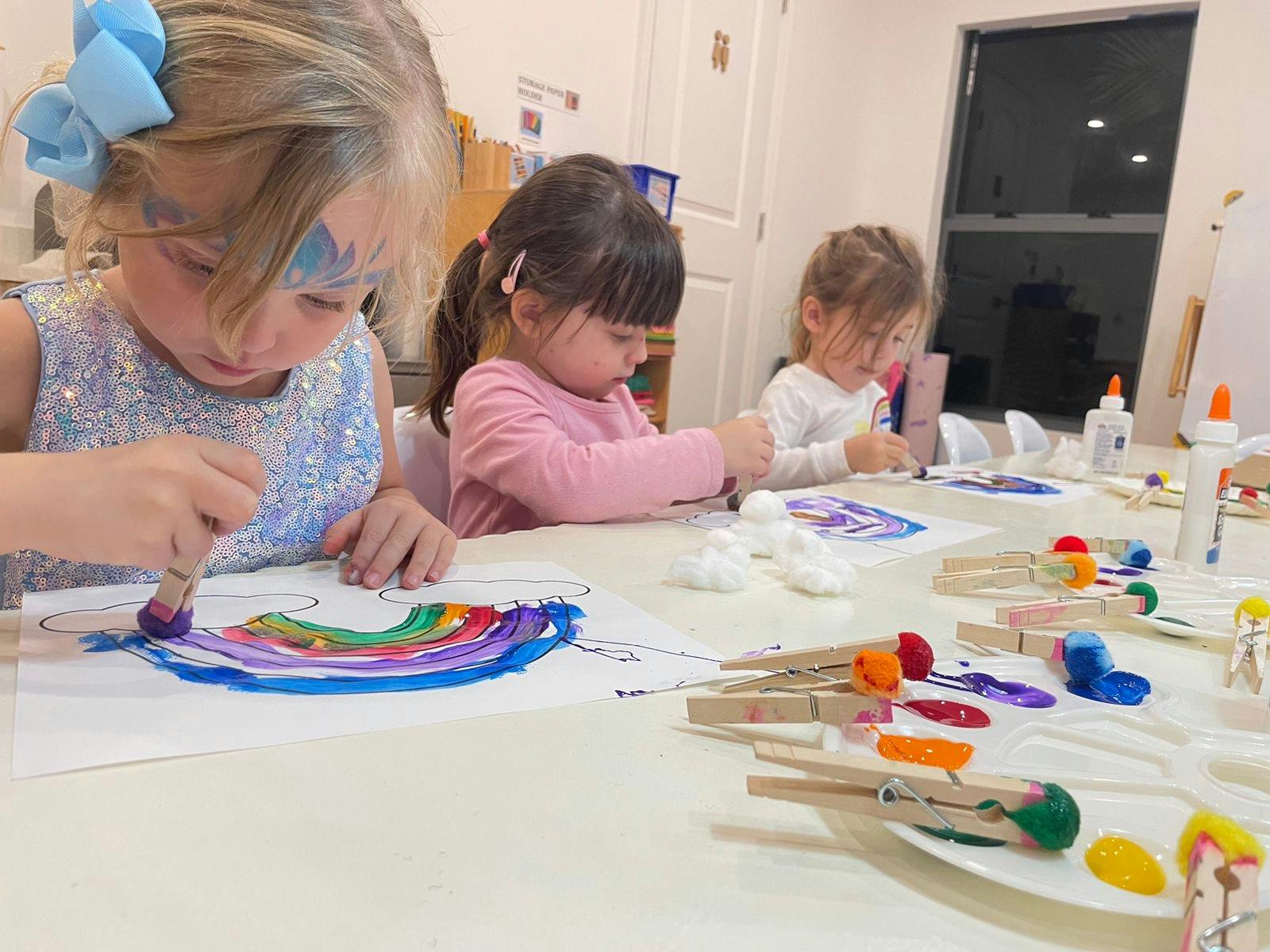 Three children painting at a table
