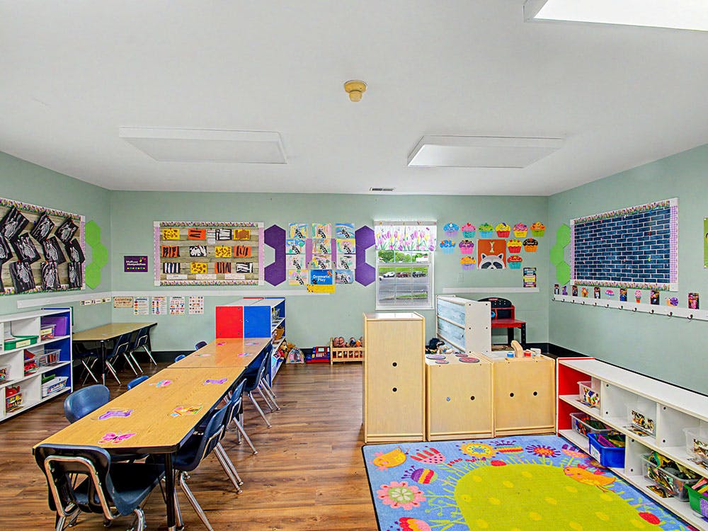 Classroom with tables, chairs, and colorful decorations on the walls