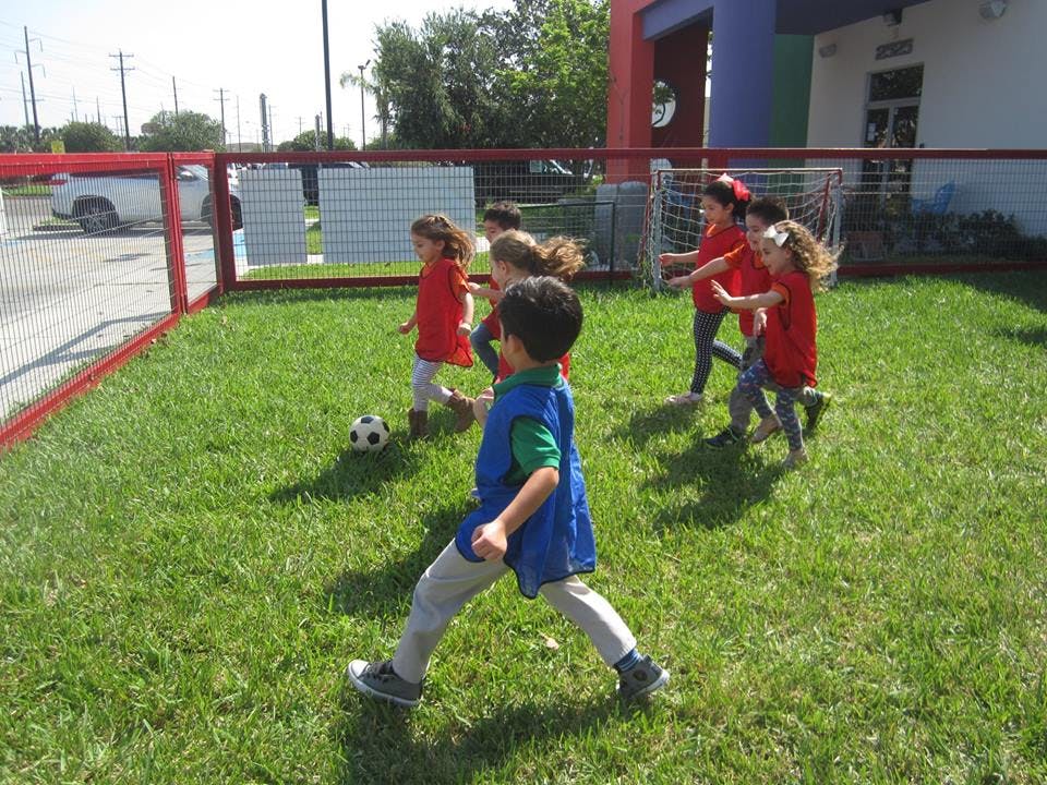 Children playing soccer on a grassy field