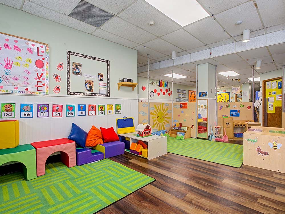 Colorful playroom with soft blocks, alphabet signs, and a sunny wall decoration