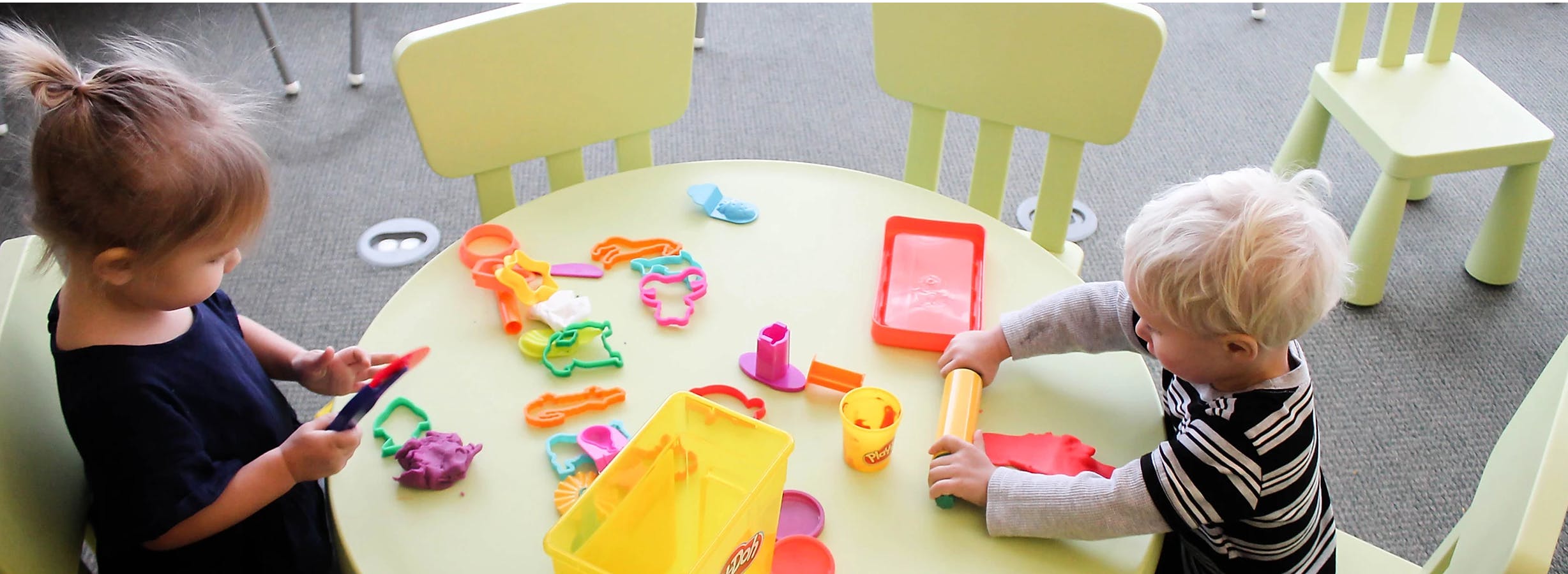 Two children playing with toys at a table