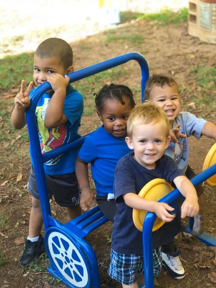 Four children on a blue playground structure
