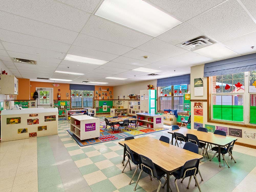 Empty classroom with small tables and chairs, colorful decorations