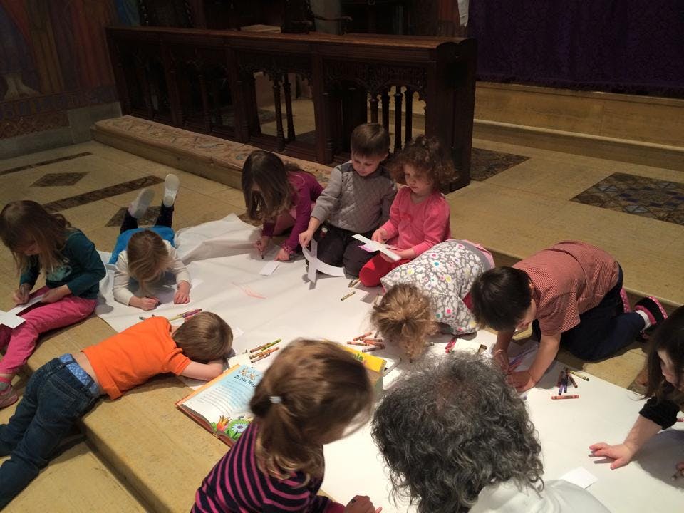 Children drawing on paper on the floor