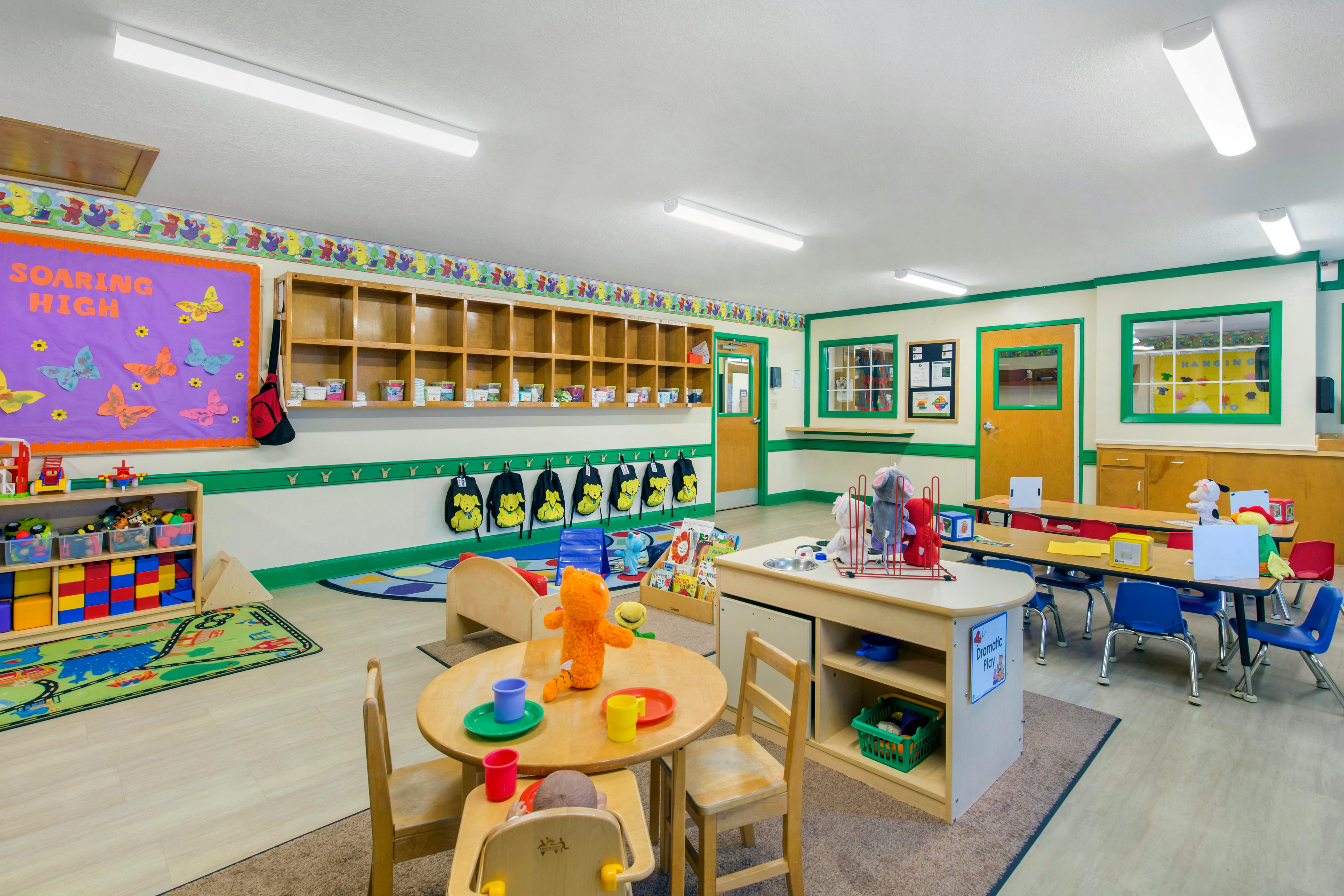 A colorful empty classroom or daycare with toys, small tables, and chairs