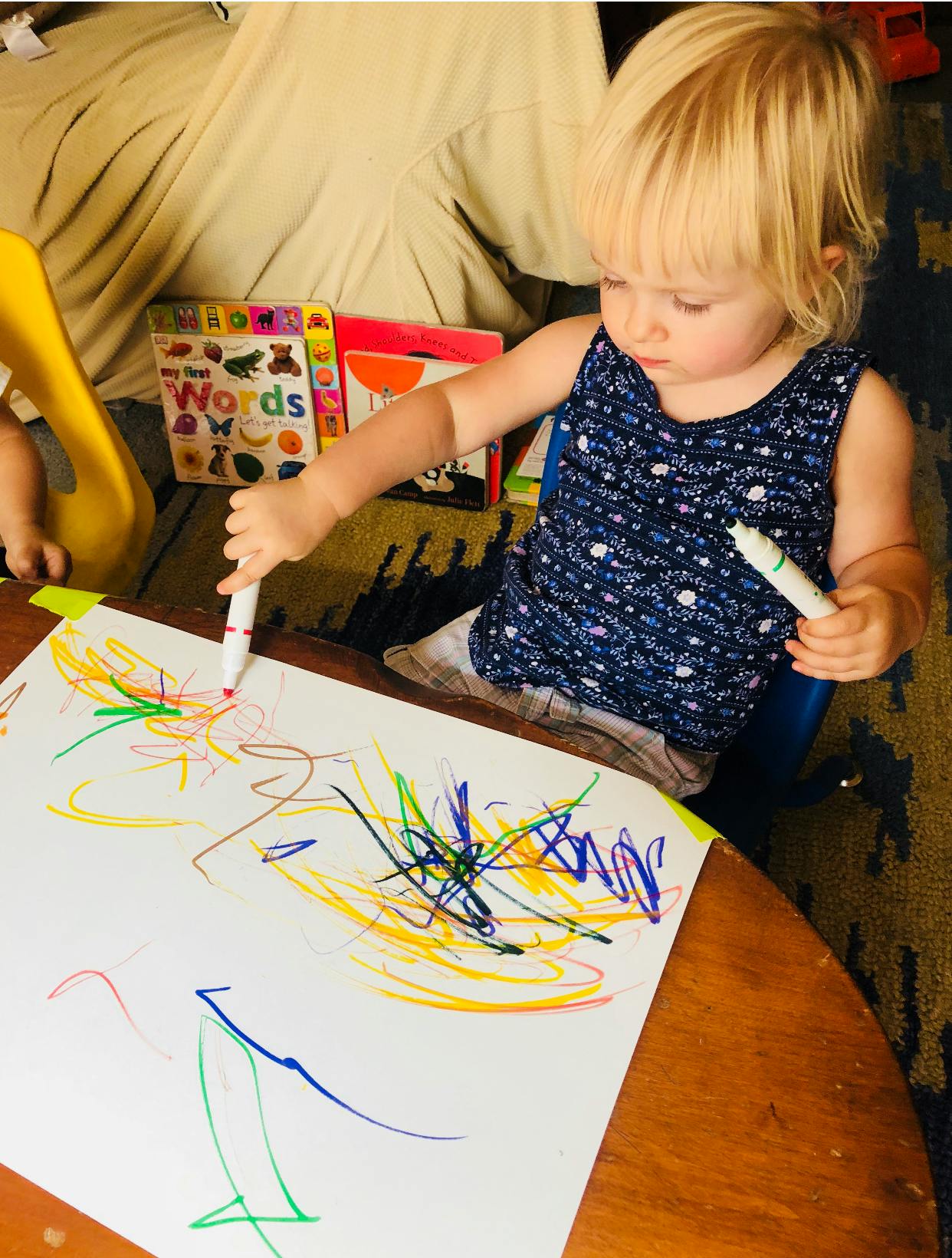 Child drawing on paper with markers
