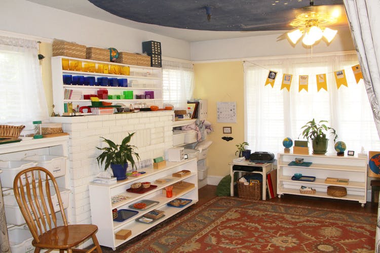 Classroom with shelves of learning materials and a patterned rug