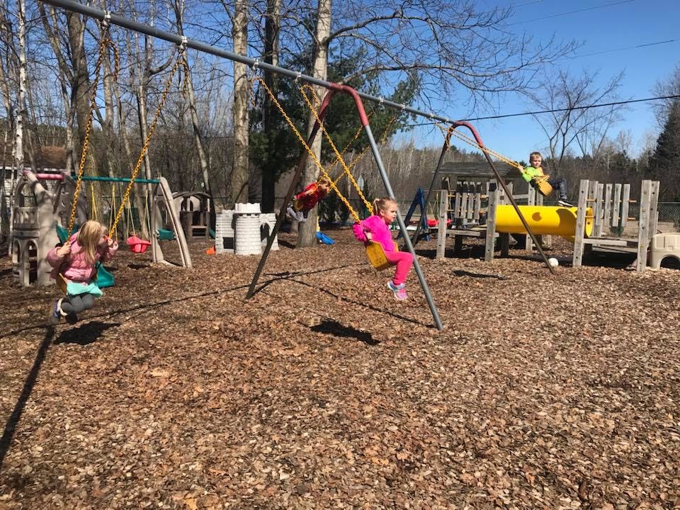 Two children swinging on a playground