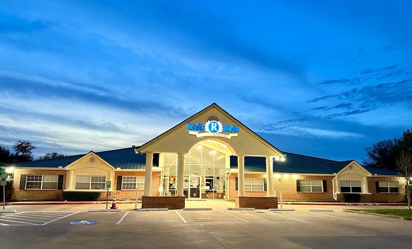 Building with a large arched entrance and a sign that says "The R"