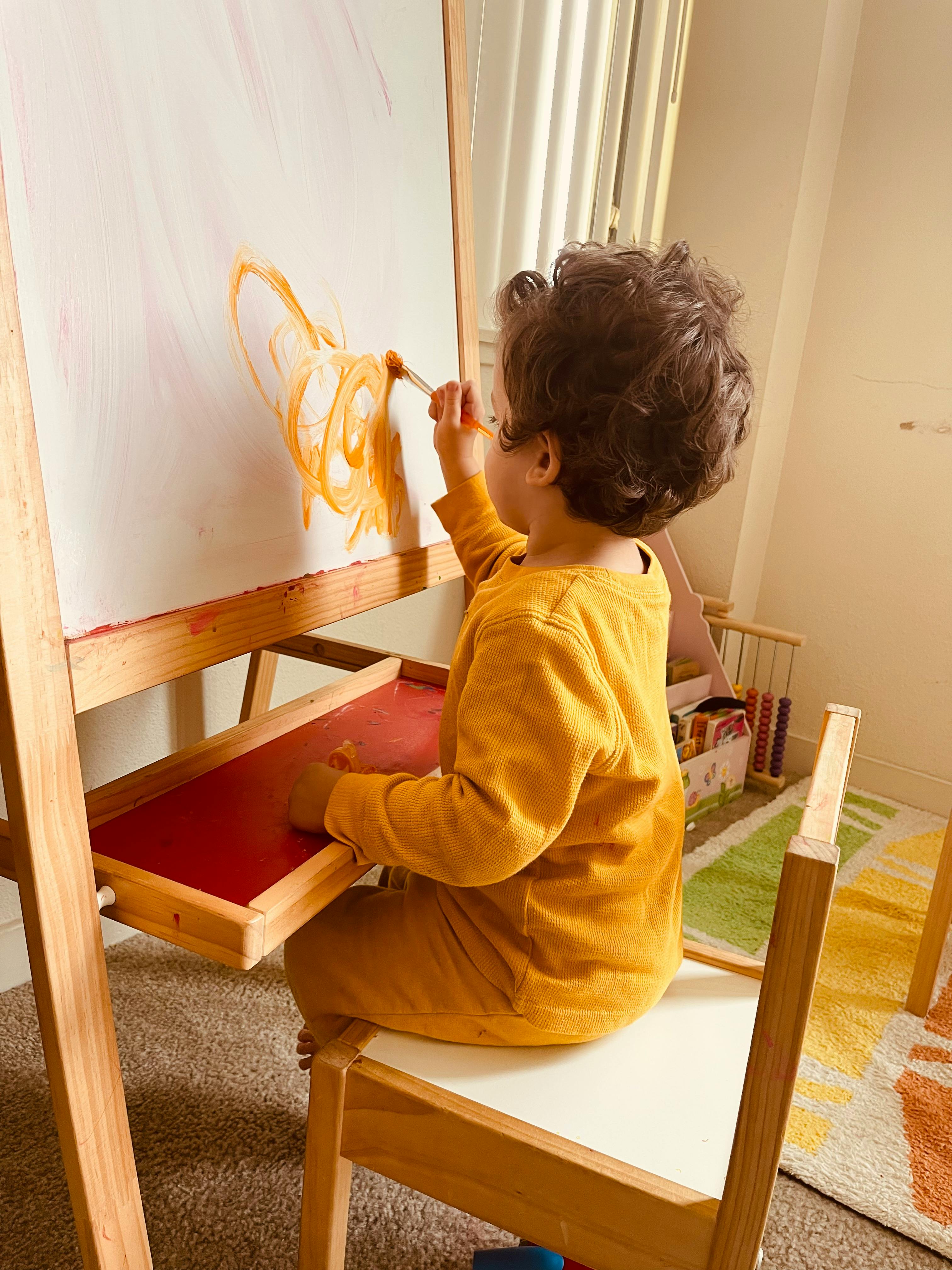 Child painting on an easel