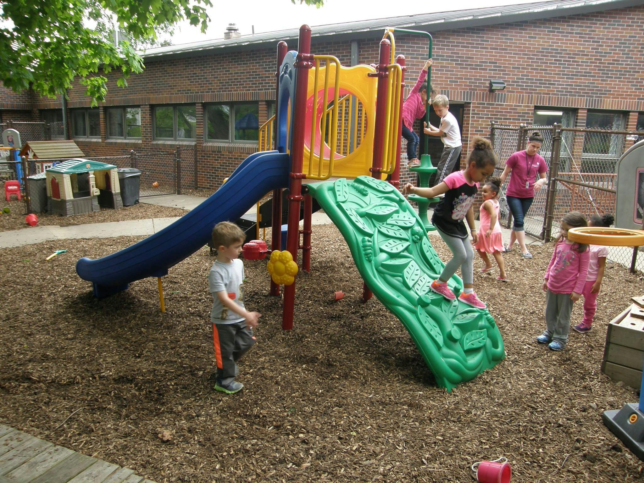 Children playing on a playground with slides and climbing structures