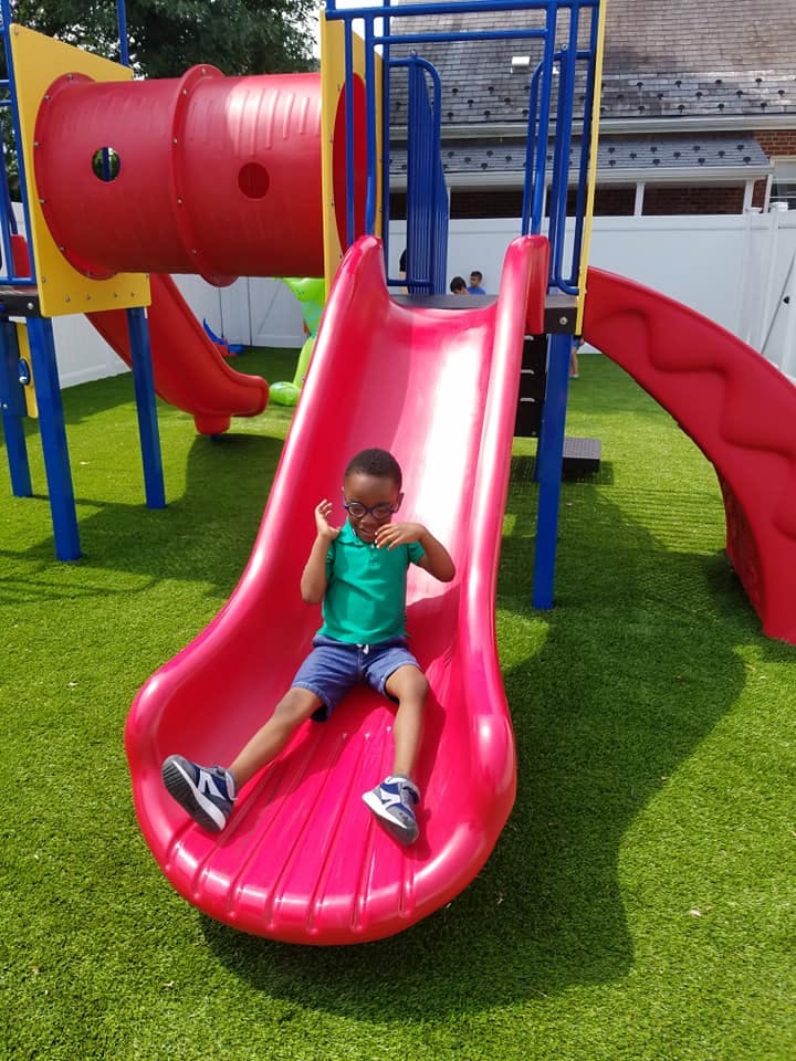 Child on a red slide at a playground