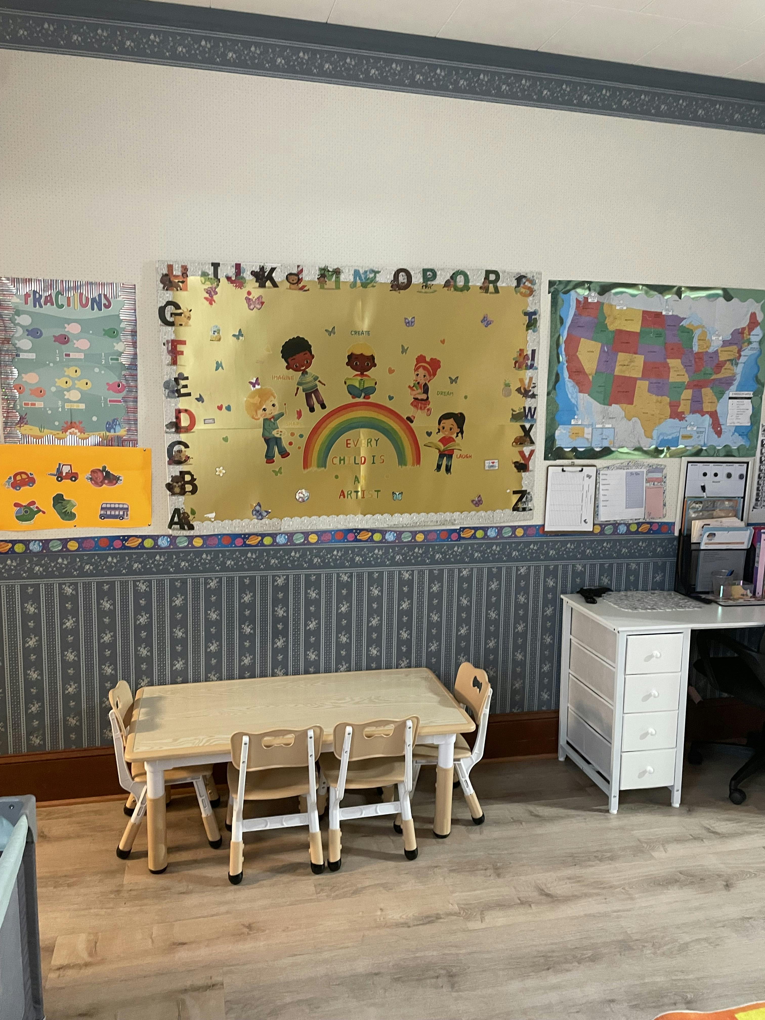 Small table and chairs in a classroom with educational posters on the wall