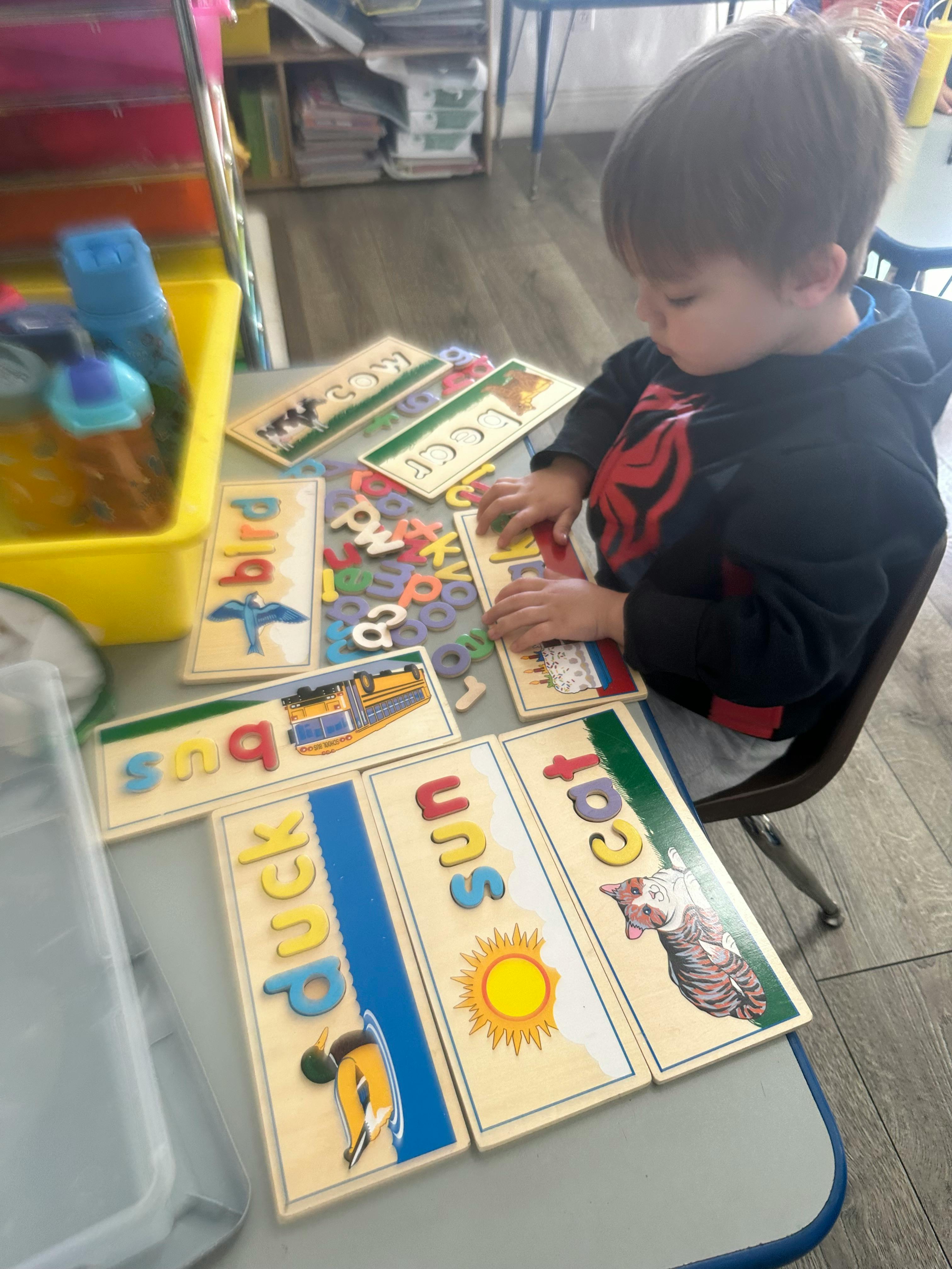 Child playing with letter puzzles on a table