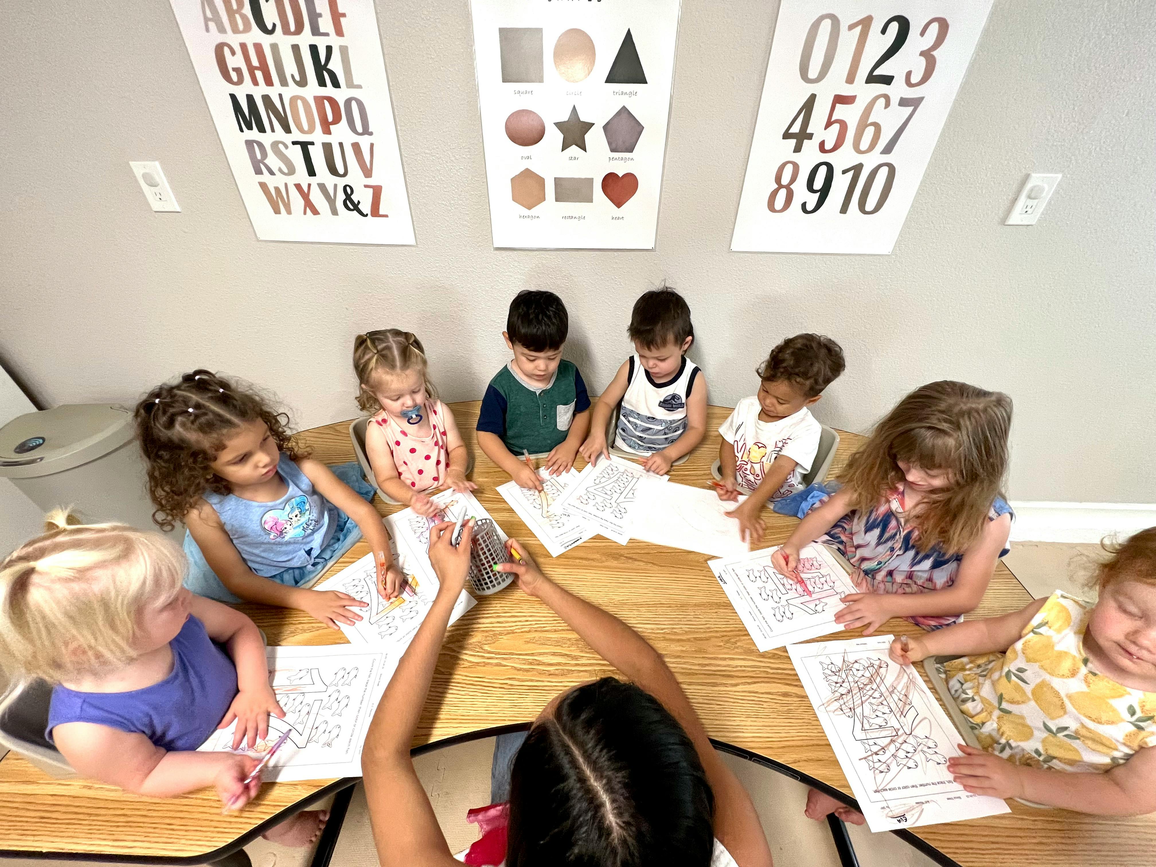 Adult and children sitting at a table with papers