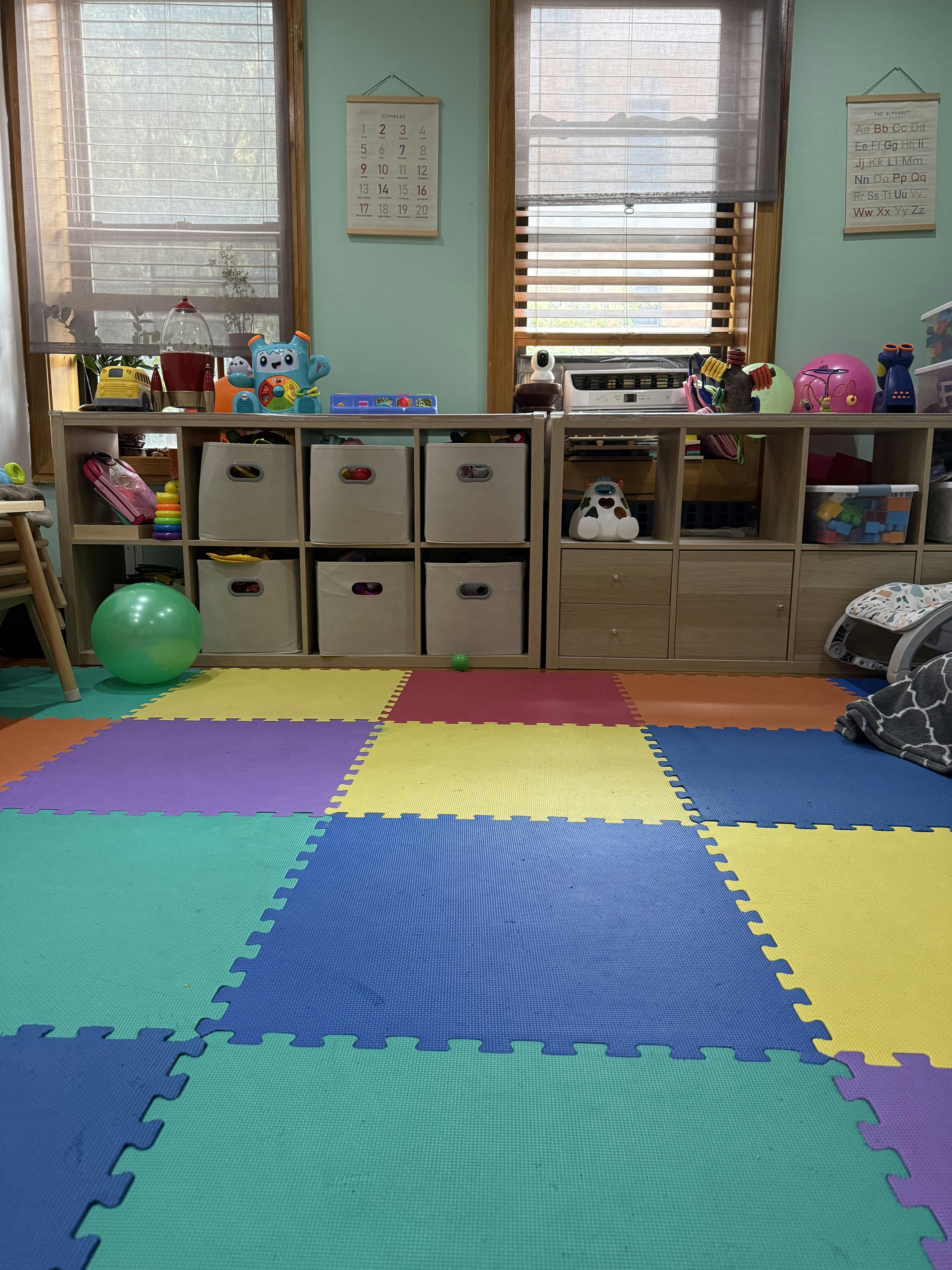 Playroom with colorful foam floor tiles and storage shelves