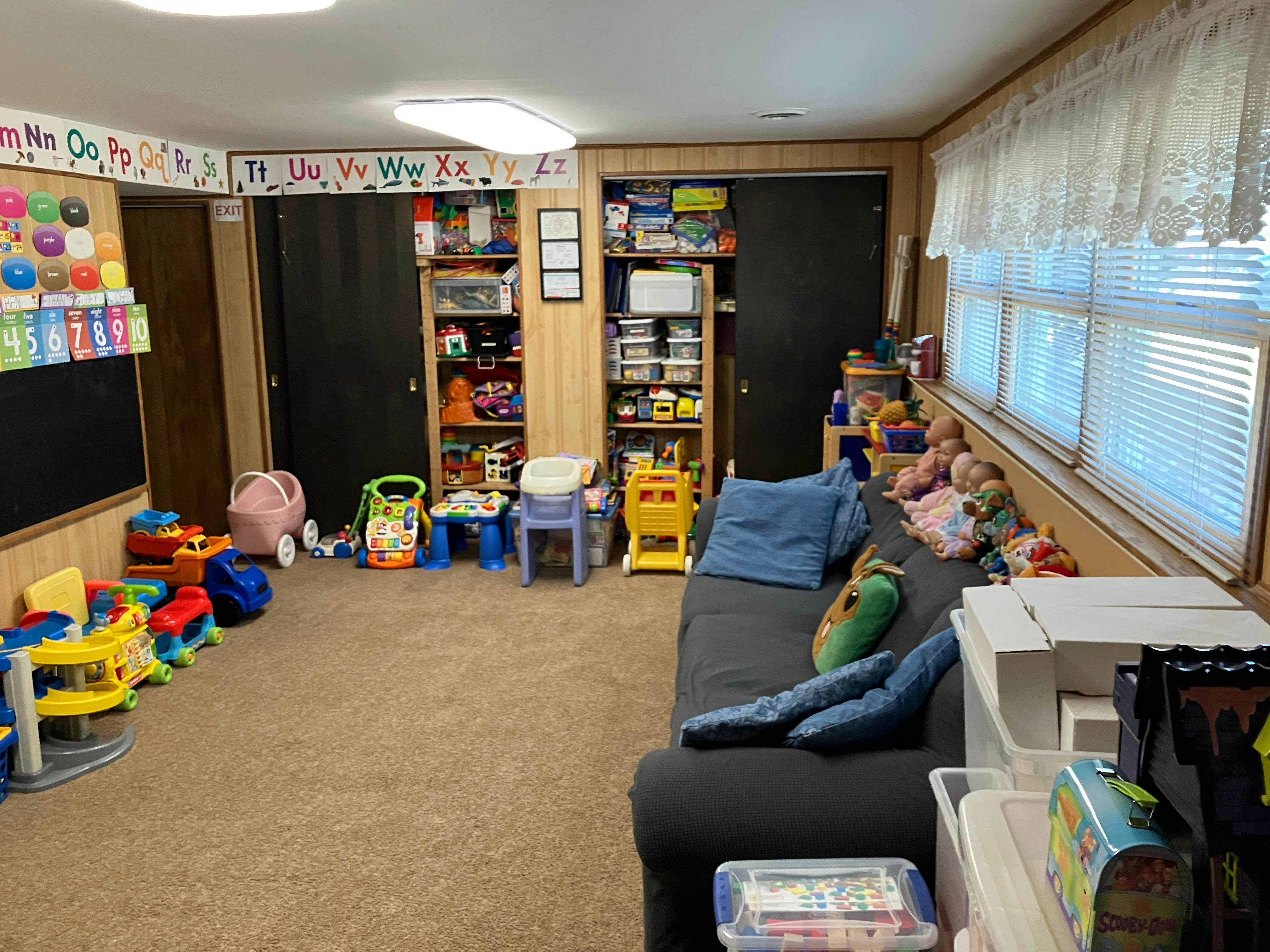 Playroom with toys, chalkboard, and alphabet border