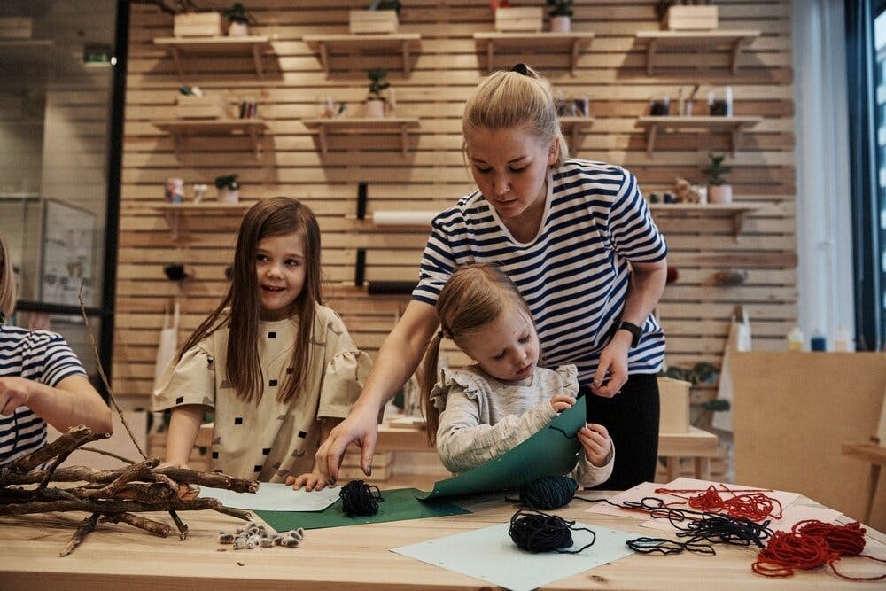 Adult and two children crafting at a table
