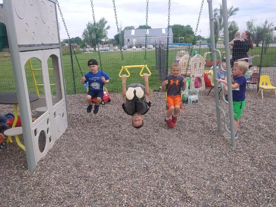 Children playing on swings and playground equipment