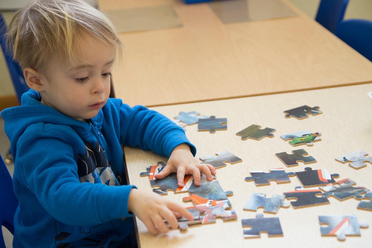 Child playing with a puzzle on a table