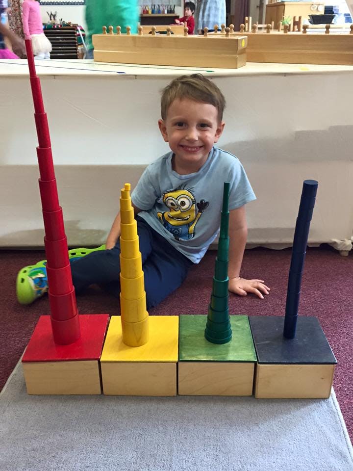 Child sitting on floor with colorful stacking toys