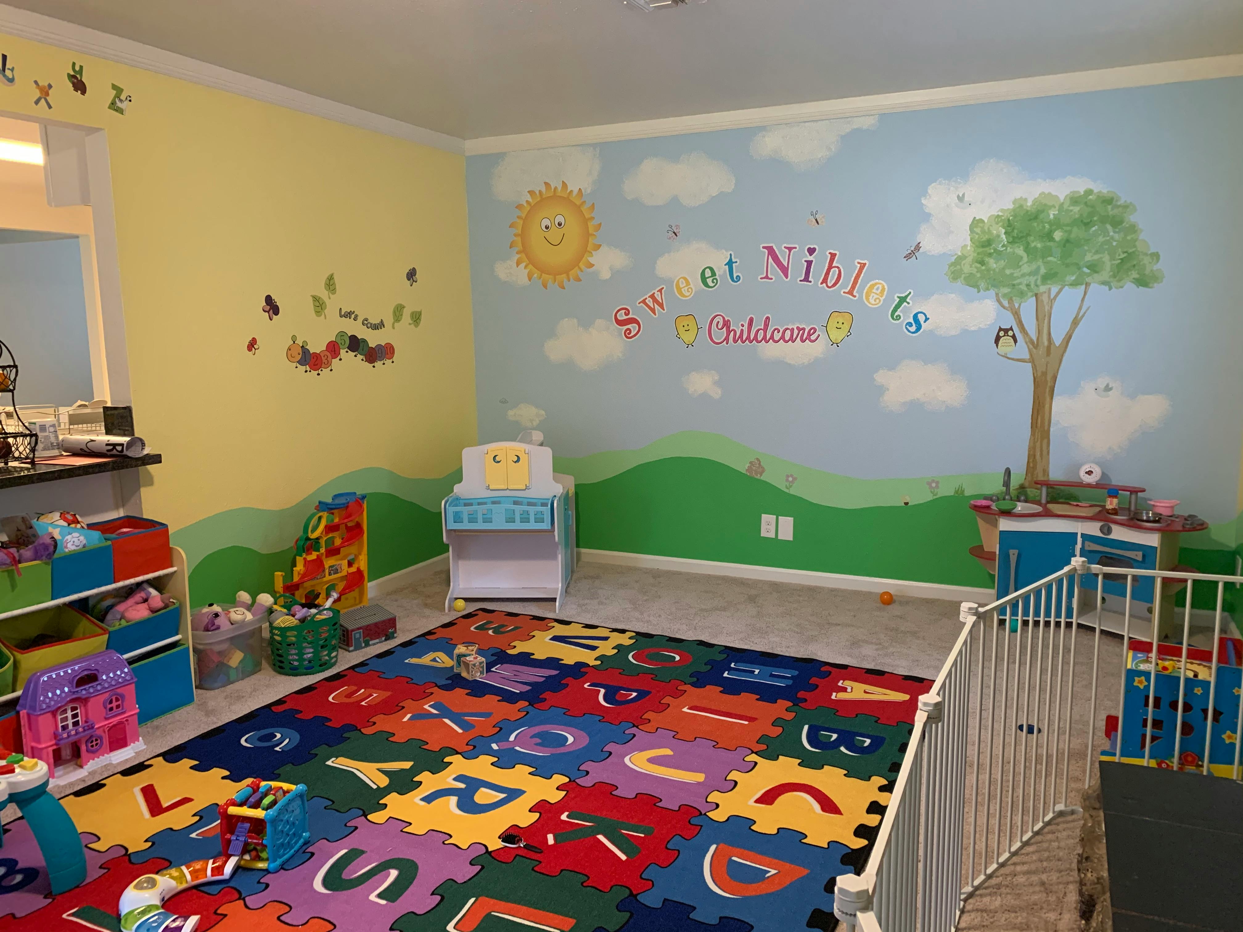 Playroom with colorful alphabet mat and wall murals