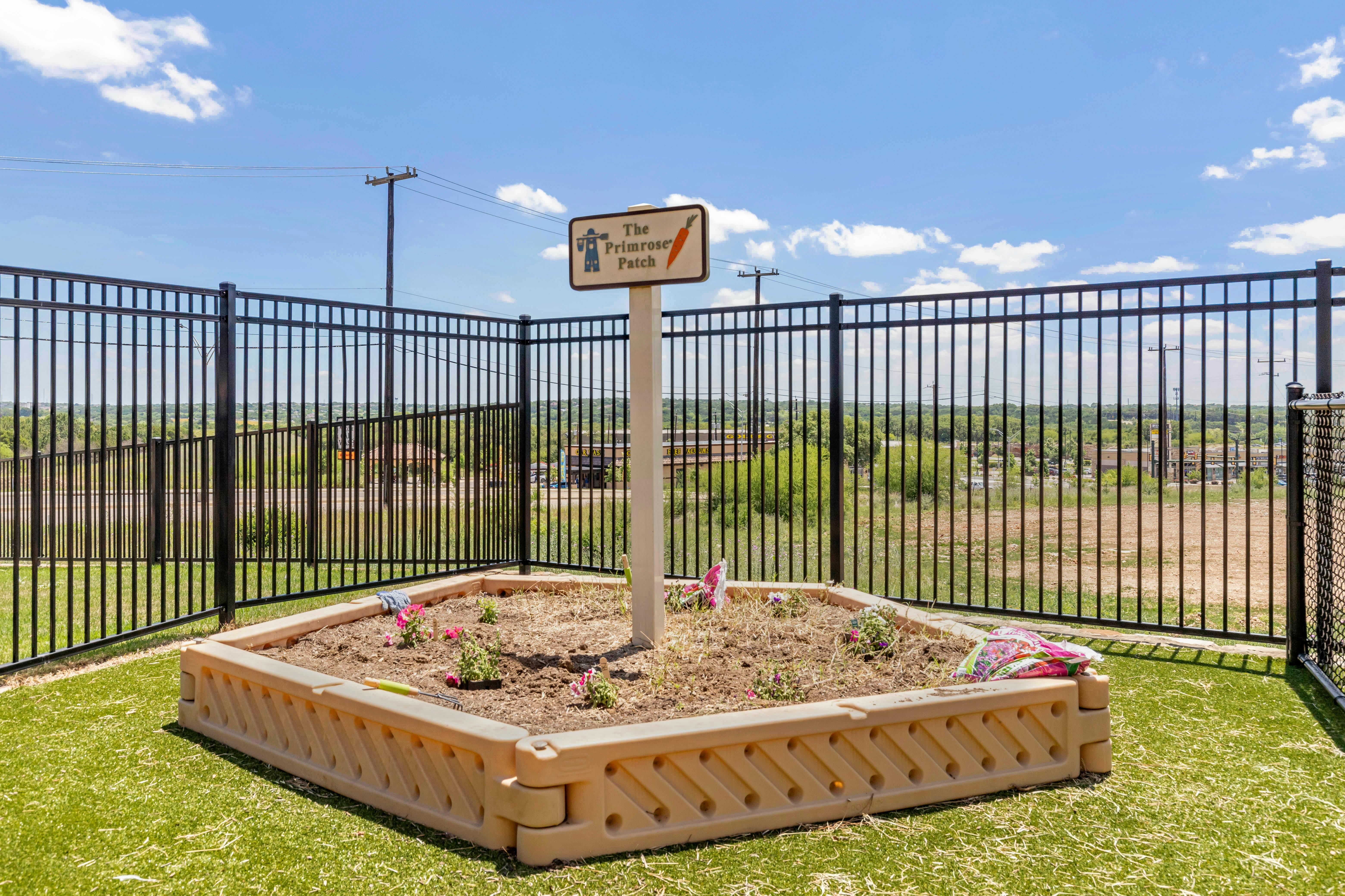 Raised garden bed with a sign for "The Primrose Patch"