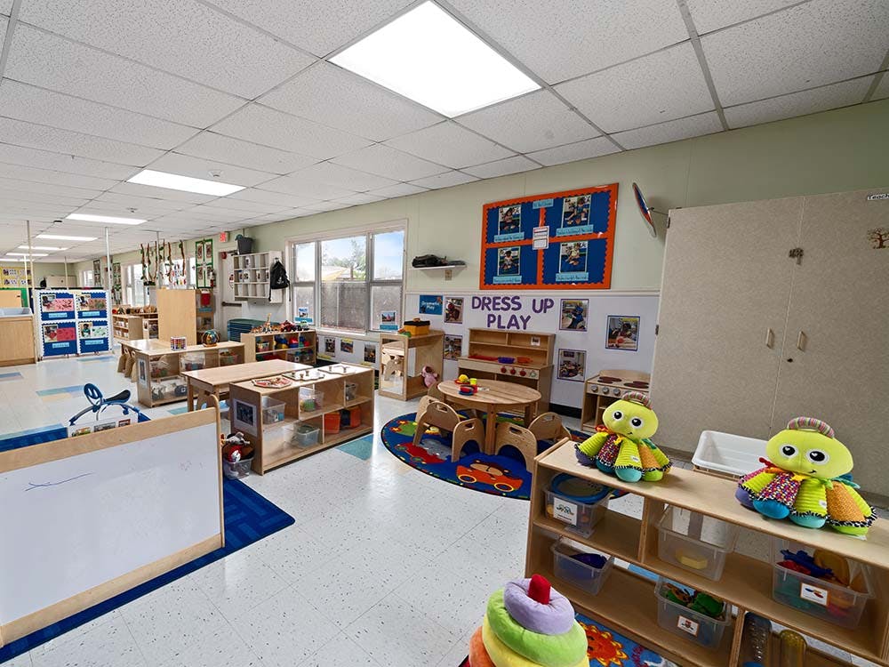 Empty colorful preschool classroom with small tables and chairs