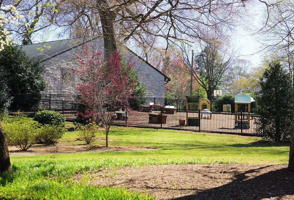 Playground with a fence and a building in the background
