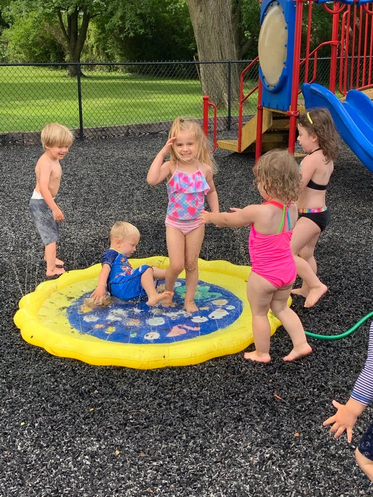 Children playing in a yellow inflatable splash pad