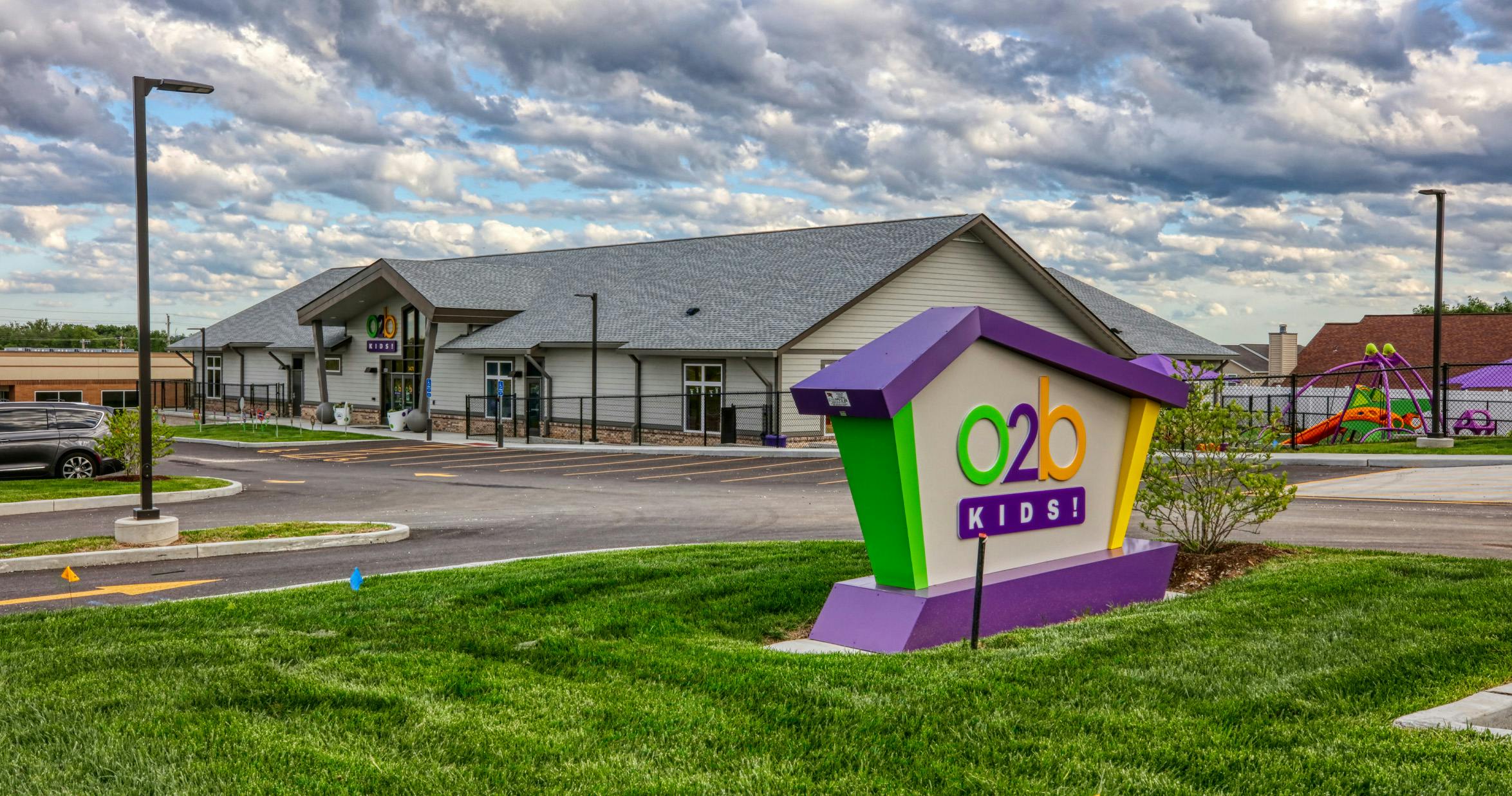 O2B Kids building and sign, with playground equipment in the background