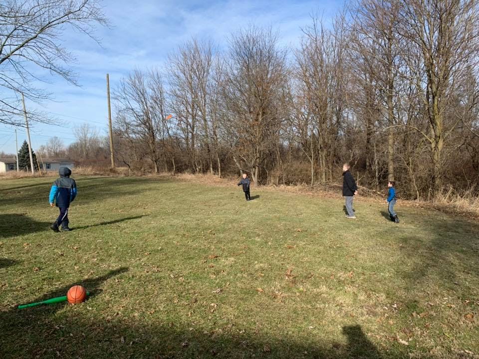 People and children playing in a grassy field