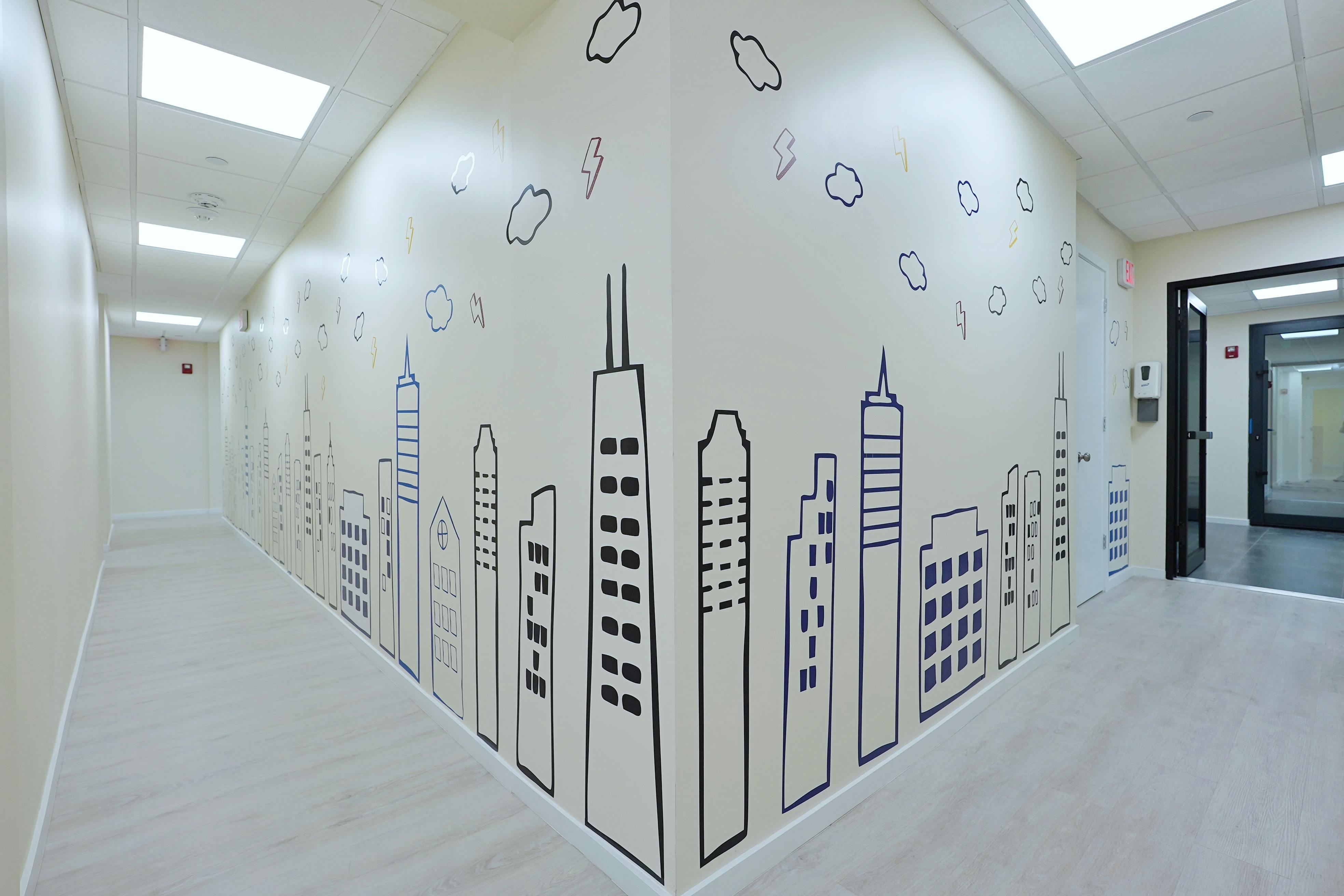 Hallway with a mural of city buildings and clouds