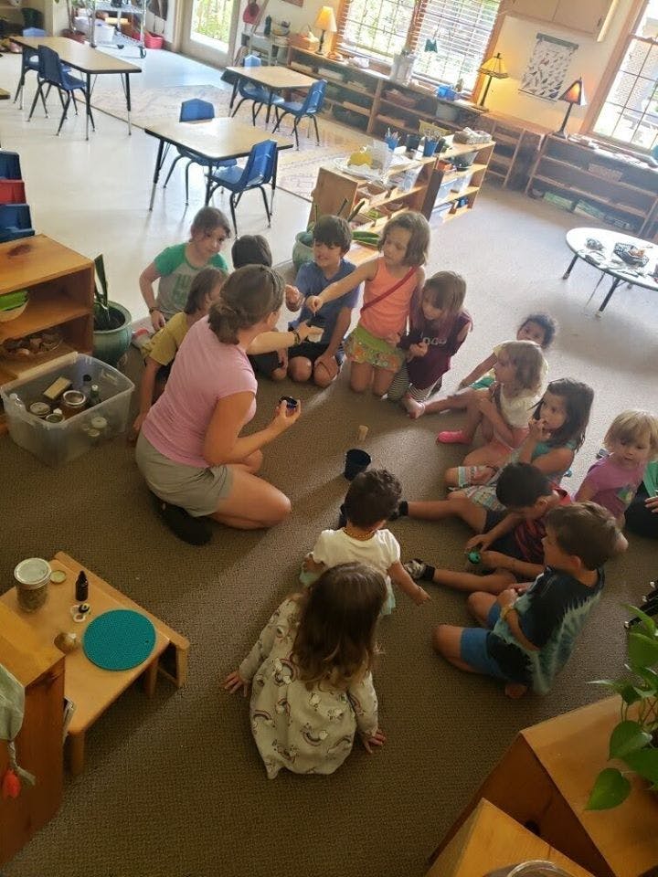Adult and children sitting on floor in a circle